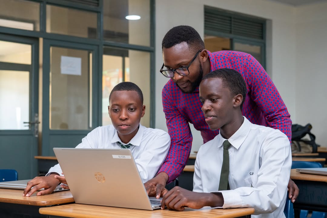 Nigerian/African teachers collaborating with tablets/laptops in a modern classroom
